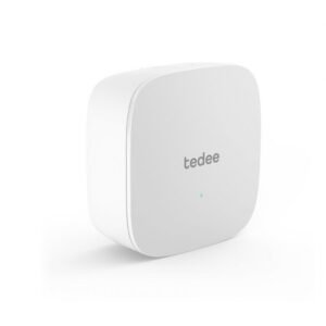 Tedee išmaniosios spynos WiFi valdiklis, baltos spalvos, suapvalintų formų dizainas su LED indikatoriumi, skirtas nuotoliniam prisijungimui prie interneto.